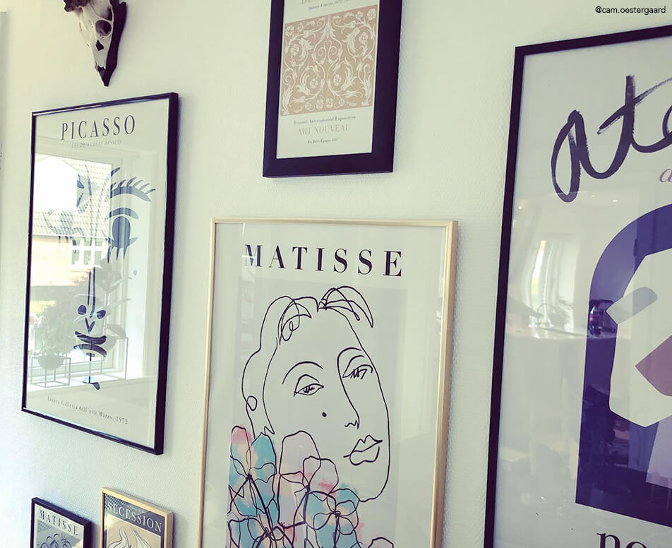 Paveikslų siena su juodais ir auksiniais rėmais